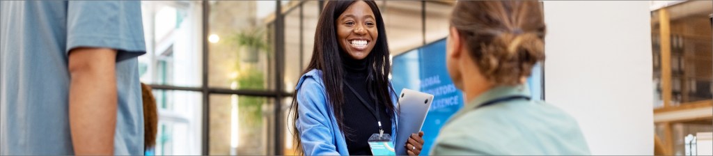 person smiling holding laptop