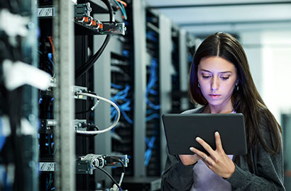 Woman looking at a tablet in a server room